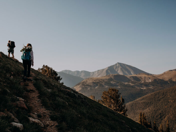wide view of the mountains while couple hikes