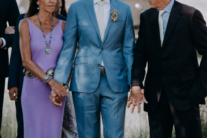 grooms parents hold his hands