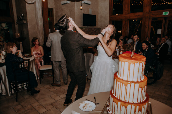 bride and groom smash cake in the others face