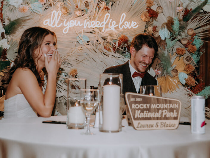 bride and groom laughing hard during toast given by best man