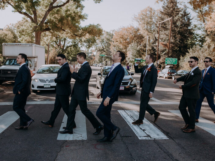 groom and groomsmen cross street laughing